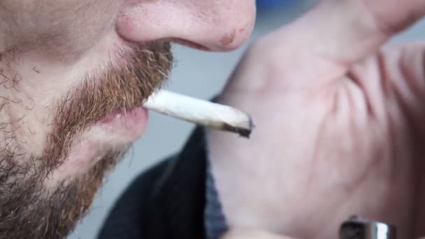 Мужчина-нищий курит сигарету — стоковое видео
