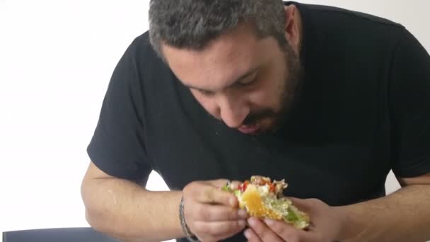 Чоловік їсть великий гамбургер — стокове відео