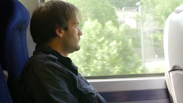 Uomo premuroso che guarda fuori dal finestrino durante un viaggio in treno — Video Stock