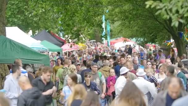 Folk folkmassan bland stativen av festivalen — Stockvideo