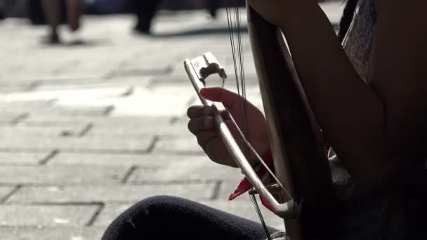 Playing a string instrument: bow, melody, street music, street artist — ストック動画