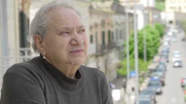 Femeie bătrână pensivă pe balcon — Videoclip de stoc