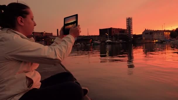 Фотография с планшетным компьютером на закате: женщина на берегу реки — стоковое видео