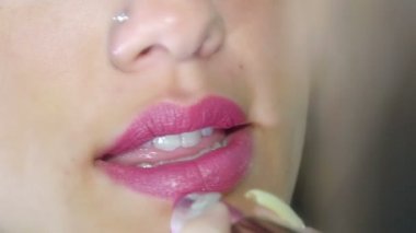 Dudaklarına ruj süren bir kadın.