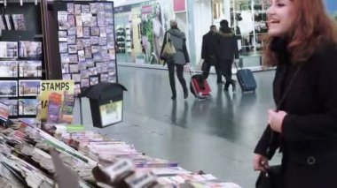 genç kadın bir tren istasyonunda bir gazete satın alıyor