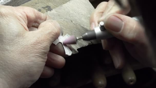 Silversmith polishes a silver cross — Stock Video