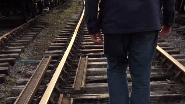 Hombre caminando en el ferrocarril — Vídeo de stock