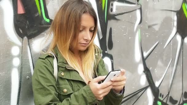 Νεαρή γυναίκα που χρησιμοποιεί smartphone στην πόλη — Αρχείο Βίντεο