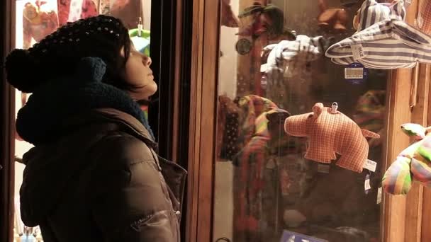 Покупки взимку: жінка перед вікном магазину одягу — стокове відео