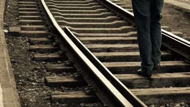 Homem caminhando para longe no meio das trilhas ferroviárias — Vídeo de Stock