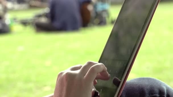 Usando la tableta en el parque — Vídeo de stock