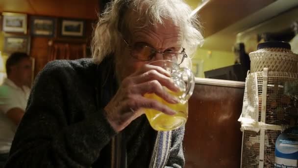 Oude eenzame man, het drinken van bier in een Engelse pub — Stockvideo