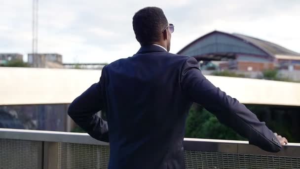 Красивий бізнесмен спирається на паркан — стокове відео