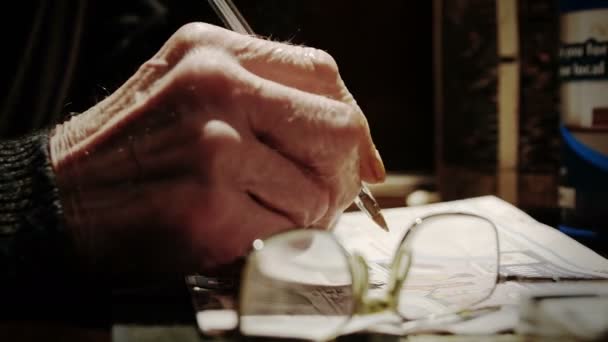 Old man's hand holding a pen and making sudoku or crosswords — Stock Video