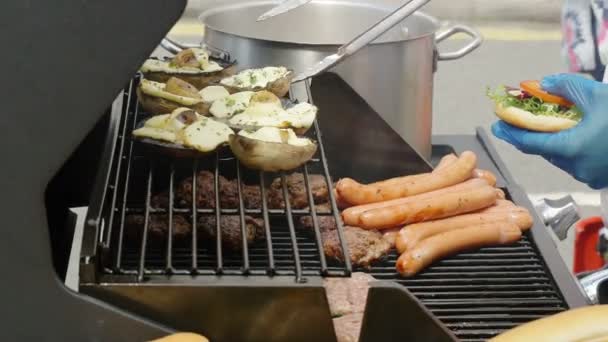 Cozinhar hambúrguer e cachorros-quentes — Vídeo de Stock