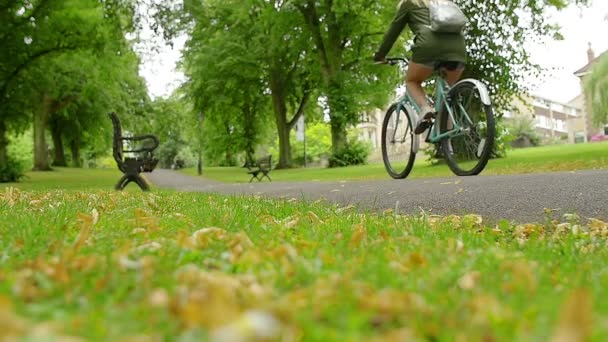 Una mujer montando una bicicleta en cámara lenta — Vídeo de stock