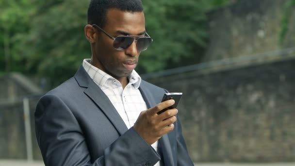 Biznesmen czarny przy użyciu telefonu komórkowego — Wideo stockowe