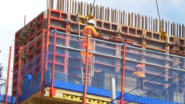 Trabajadores en el trabajo en una obra de construcción para construir un rascacielos — Vídeos de Stock