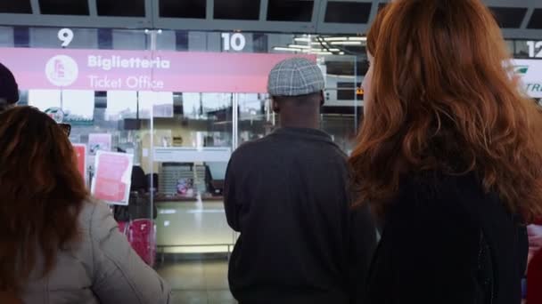 Tren bilet gişesi yakınındaki tren istasyonu içinde bekleyen kadın — Stok video