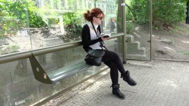 genç kadın Turist Rehberi Prag'da otobüs durağında okuma