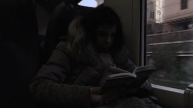 genç kadın bir turist rehberi trende okuma