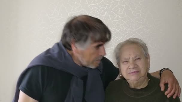 En mogen man kysser på kinden hans åldriga mor — Stockvideo