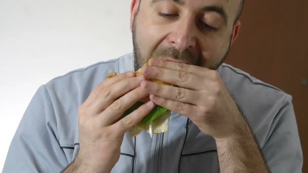 Людина їсть гамбургер — стокове відео