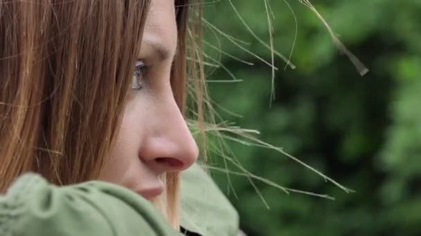 Pensive sad woman leaning a fence in a windy day — Stock Video