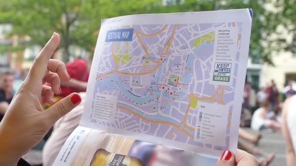 Stadtplan konsultieren: Nahaufnahmen auf Händen, die den Punkt über der Karte angeben — Stockvideo