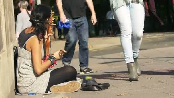 Mujer mendigo artista callejero jugando en la acera — Vídeos de Stock