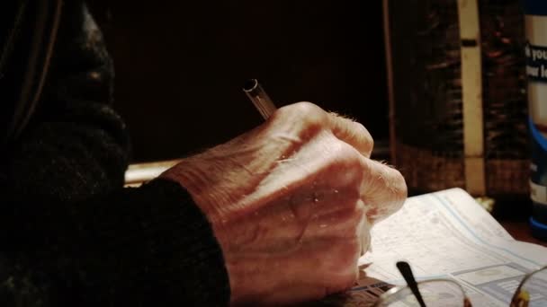 Hände eines älteren Mannes beim Kreuzworträtsel oder Sudoku — Stockvideo