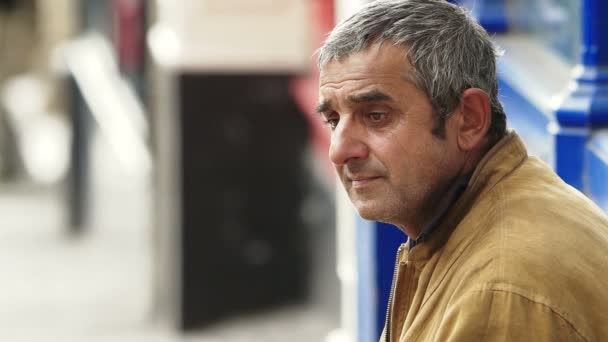 Sin un techo sobre la cabeza. Hombre sin hogar sentarse en el paseo lateral — Vídeos de Stock
