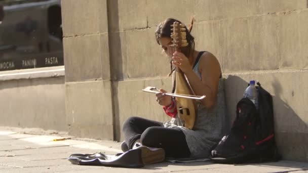 Begging street artist sitting on the trowalk — стоковое видео