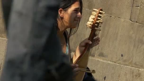 Artista callejero sentado en la acera entre la gente — Vídeos de Stock