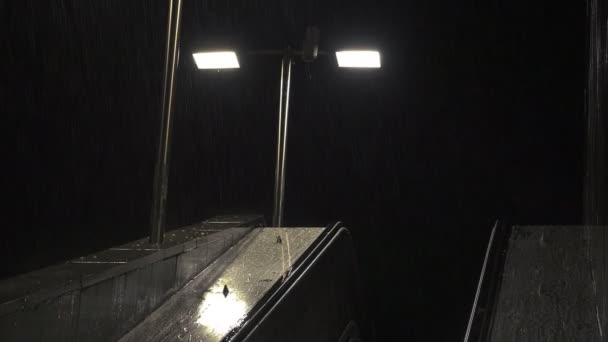 Βροχή το βράδυ πάνω από την πόλη λαμπτήρες — Αρχείο Βίντεο