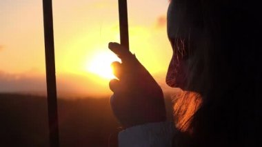 bir demir çit arkasındaki çaresiz kadın