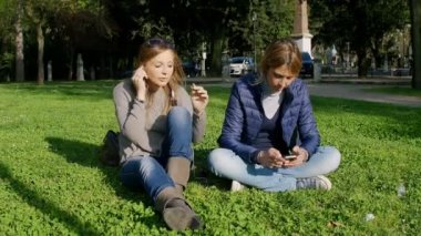 Kız parkta çim: smartphone ve müzik ile eğleniyor