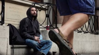 Şehir merkezinde bir meşgul sokakta yalvarıyor evsiz bir dilenci