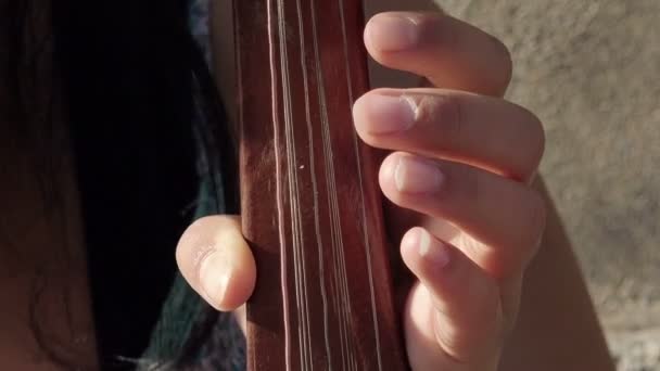 Mãos de mulher jovem tocando um instrumento de corda na rua — Vídeo de Stock