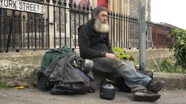 Бездомный сидит на улице — стоковое видео