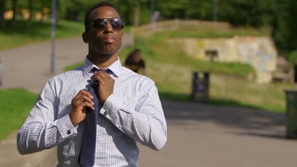 Black businessman adjusting black tie — Stock Video