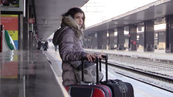 Mujer joven esperando para salir en la estación de tren con muchos equipajes — Vídeo de stock