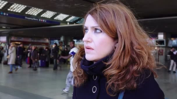 Mujer joven esperando la salida del tren en una estación de tren — Vídeos de Stock