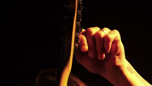 Muzikant tunes een gitaar tijdens een concert — Stockvideo