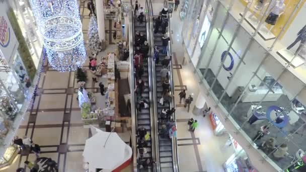 Um shopping gigante com grandes escadas rolantes e muitas pessoas fazendo compras — Vídeo de Stock