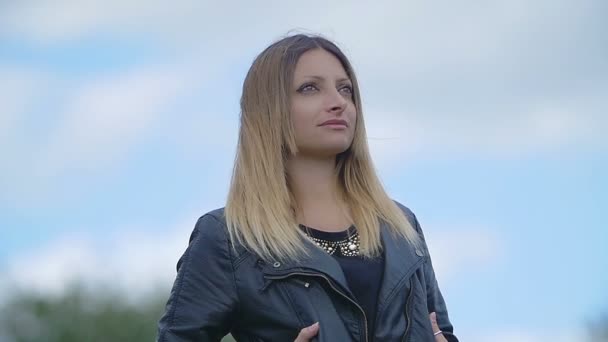 Mladá krásná žena portrét proti modré obloze — Stock video