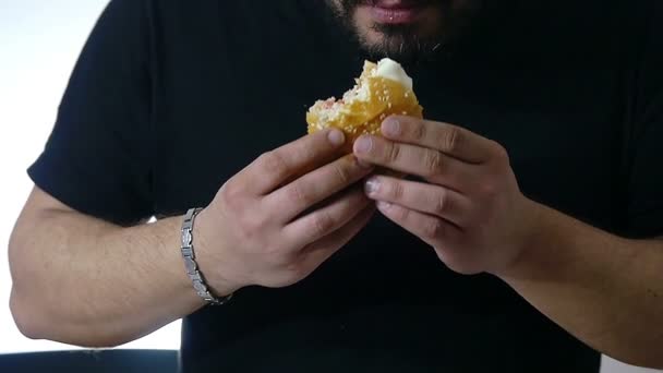 若い男がハンバーガーを食べて — ストック動画