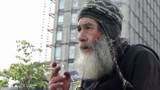 Az utcán idős hajléktalan dohányzás — Stock videók
