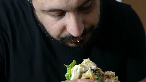 Jovem comendo um hambúrguer — Vídeo de Stock