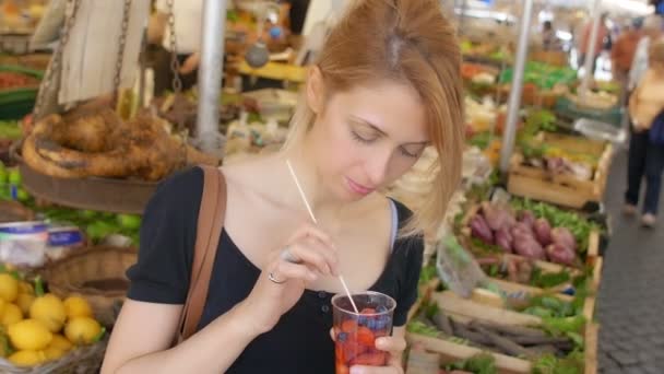 Mujer comiendo frutas en el mercado — Vídeos de Stock